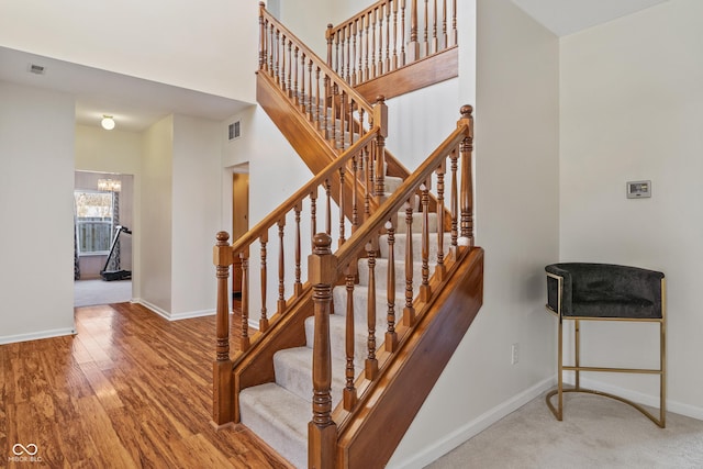 stairs featuring a notable chandelier and hardwood / wood-style flooring