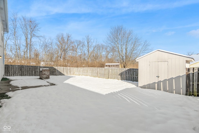 yard covered in snow with a storage shed