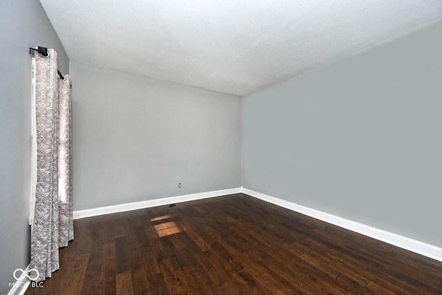 spare room with dark wood-type flooring and a textured ceiling