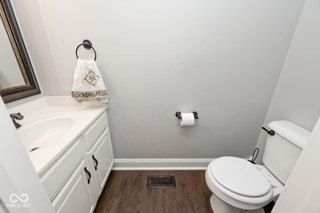 bathroom featuring toilet, wood-type flooring, and vanity