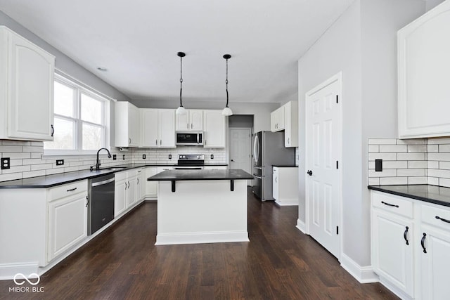 kitchen featuring pendant lighting, white cabinetry, a center island, and stainless steel appliances