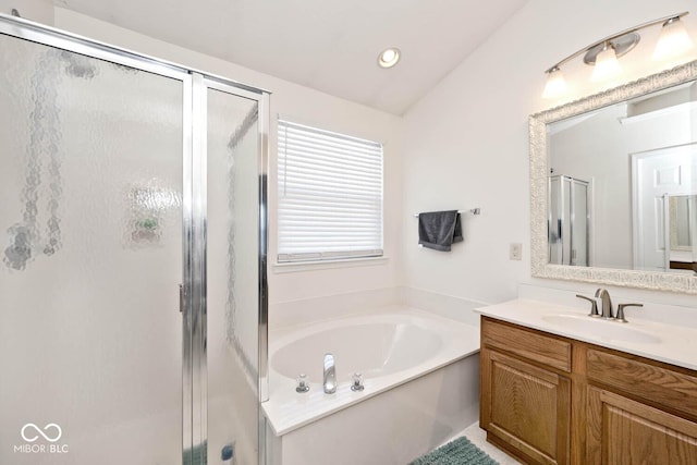 bathroom with vanity, separate shower and tub, and vaulted ceiling