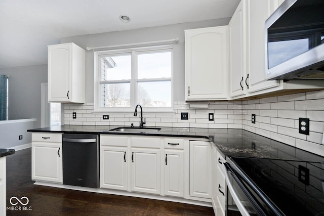 kitchen featuring appliances with stainless steel finishes, white cabinetry, decorative backsplash, sink, and dark hardwood / wood-style floors