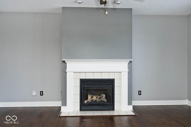 details with hardwood / wood-style floors and a tiled fireplace