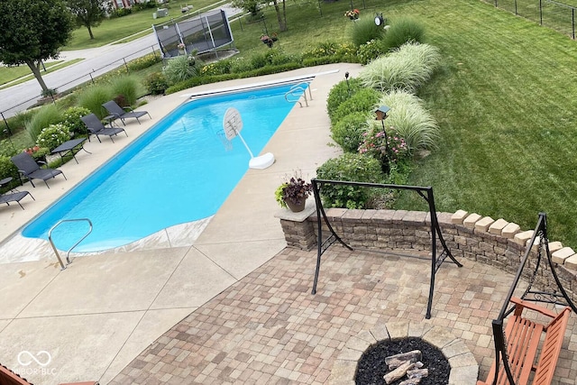 view of pool featuring a patio area, an outdoor fire pit, and a yard