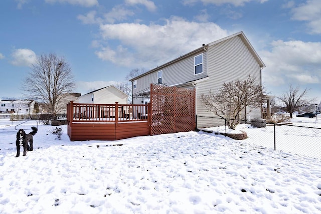 snow covered back of property featuring a wooden deck