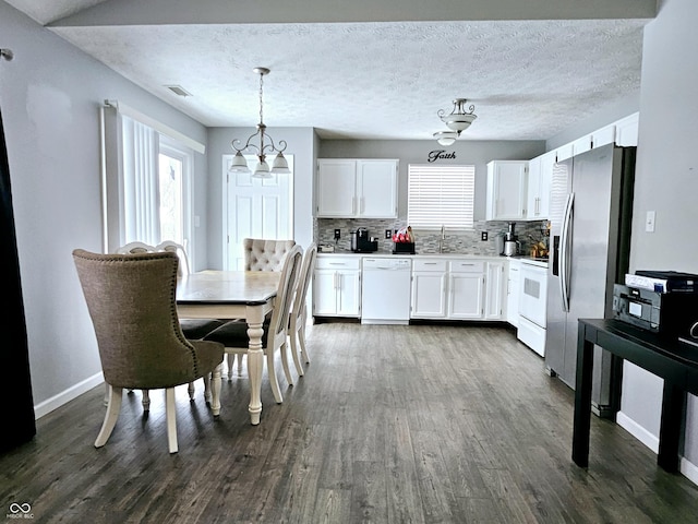 kitchen with white cabinets, white appliances, decorative light fixtures, and backsplash