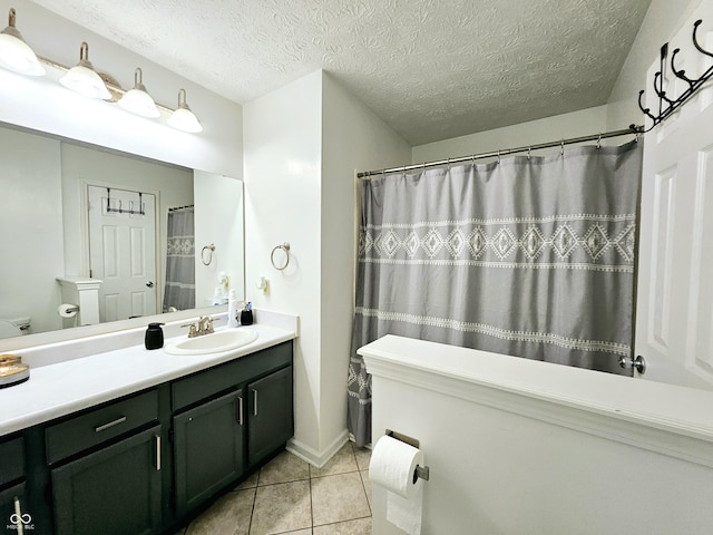 bathroom featuring tile patterned flooring, vanity, and a textured ceiling