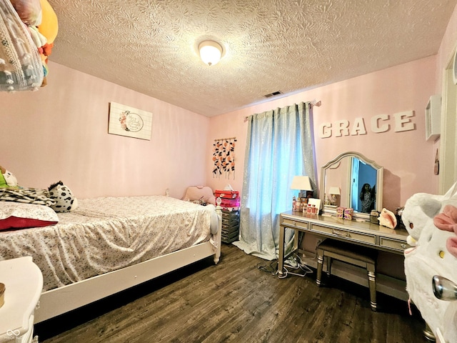 bedroom featuring a textured ceiling and dark hardwood / wood-style flooring