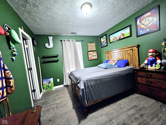 bedroom with wood-type flooring and a textured ceiling