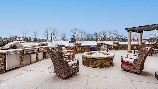 snow covered patio featuring an outdoor fire pit, area for grilling, and a pergola