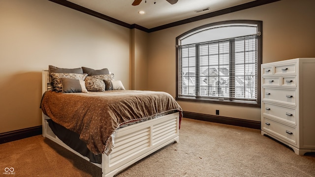 carpeted bedroom featuring ceiling fan and crown molding