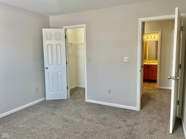 unfurnished bedroom with carpet, a walk in closet, and a closet