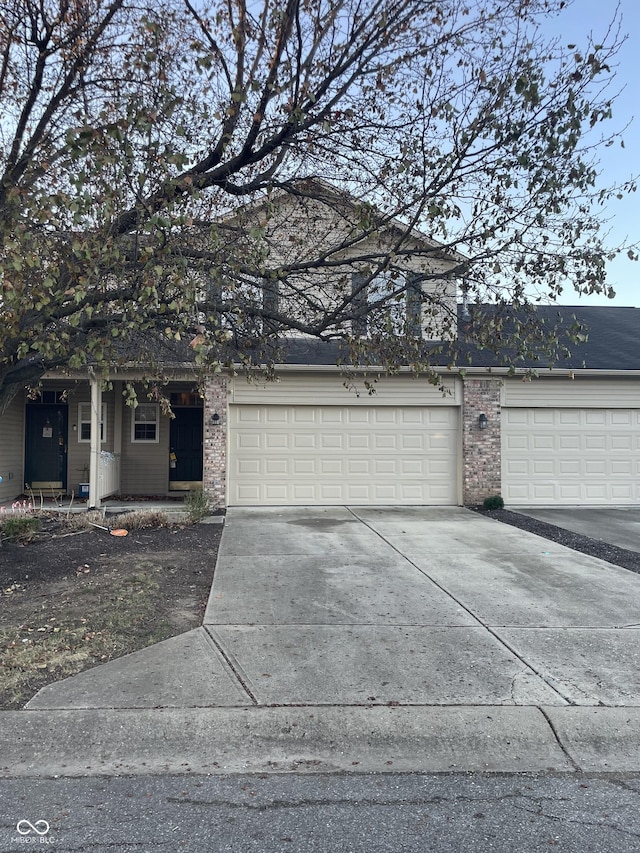 view of front facade with concrete driveway, brick siding, and an attached garage