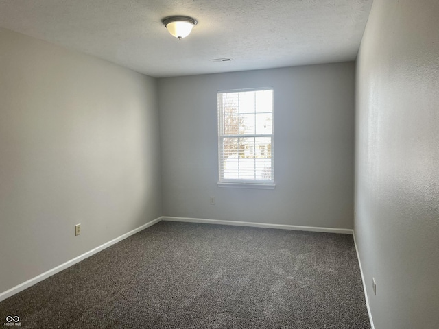 carpeted empty room with a textured ceiling