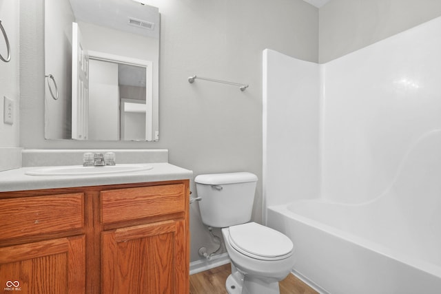 bathroom with visible vents, shower / bath combination, toilet, vanity, and wood finished floors