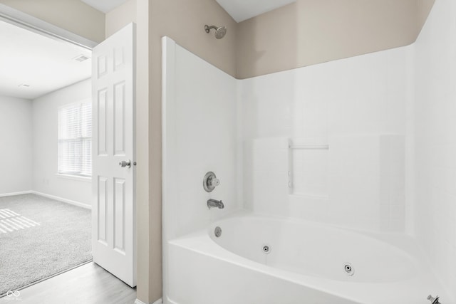 bathroom featuring a combined bath / shower with jetted tub, visible vents, and baseboards