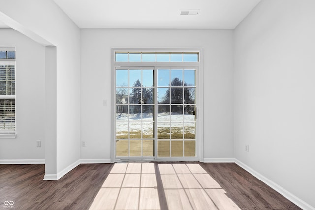 entryway with dark wood-type flooring, visible vents, and baseboards