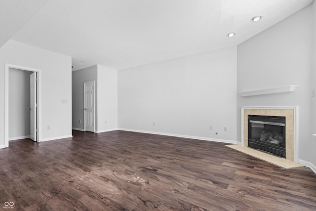 unfurnished living room featuring dark wood-style floors, a fireplace, and baseboards