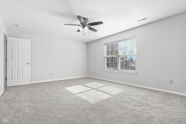 carpeted empty room with a ceiling fan and baseboards