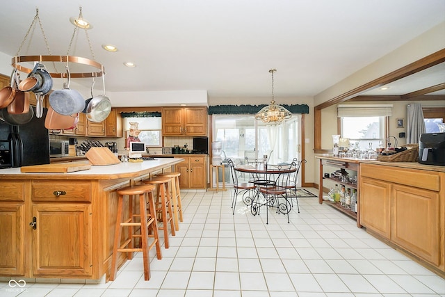 kitchen featuring a kitchen island, plenty of natural light, a kitchen breakfast bar, and hanging light fixtures