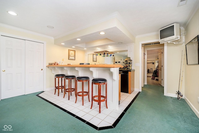 kitchen with crown molding, light colored carpet, a breakfast bar, and kitchen peninsula