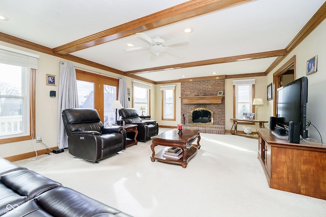 living room featuring a fireplace, ornamental molding, light colored carpet, ceiling fan, and beam ceiling