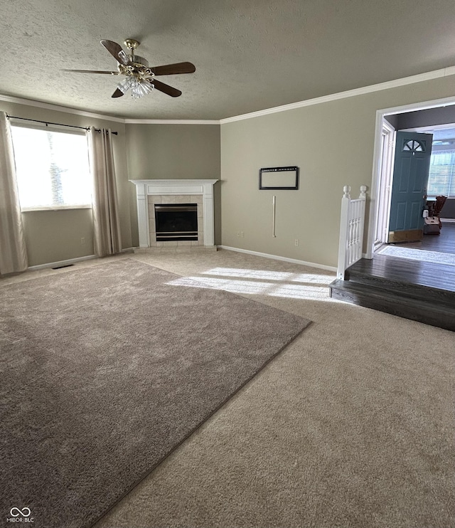 unfurnished living room featuring a fireplace, a textured ceiling, ceiling fan, and carpet flooring