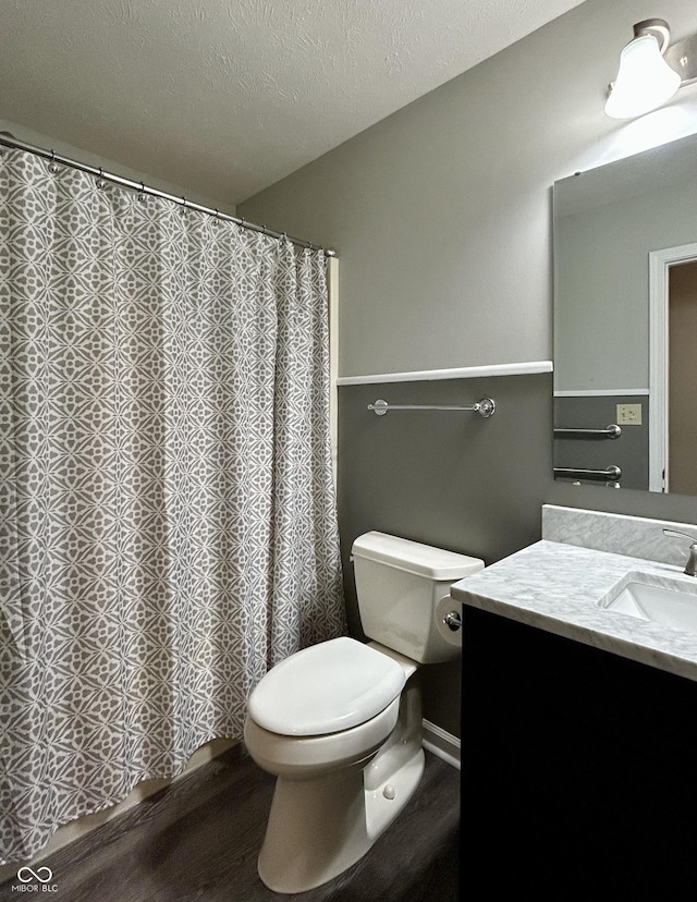 bathroom featuring vanity, toilet, and a textured ceiling