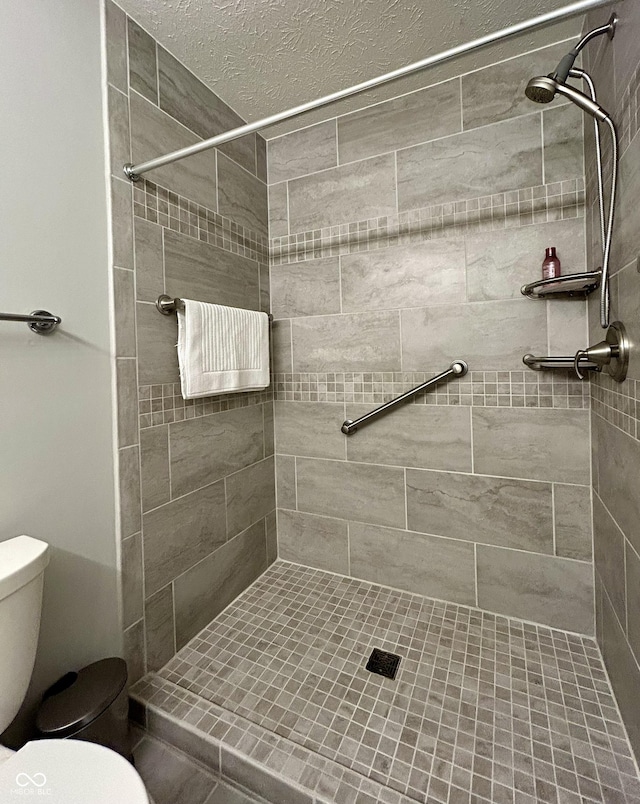 bathroom featuring tiled shower and toilet