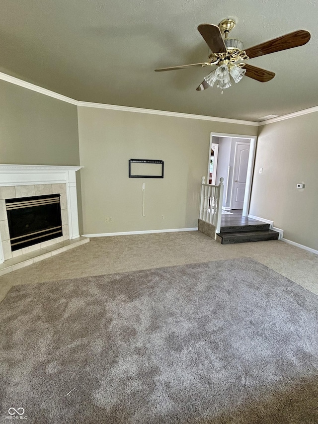 unfurnished living room featuring a fireplace, carpet flooring, ceiling fan, and ornamental molding