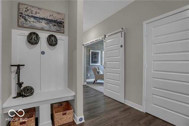 mudroom with dark wood-style floors, a barn door, and baseboards