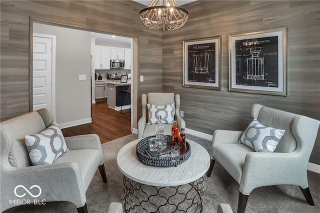 living area featuring dark wood-style floors, baseboards, and a chandelier