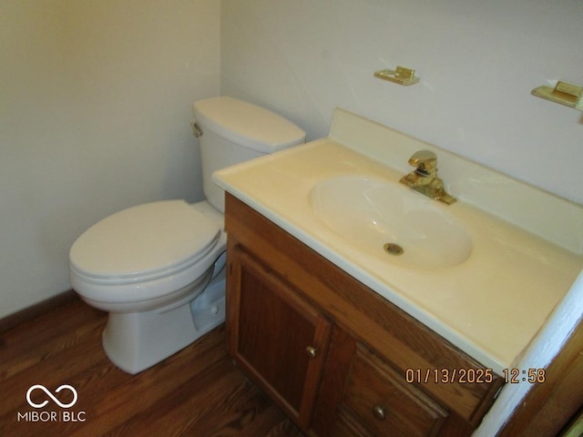 bathroom featuring vanity, toilet, and wood finished floors