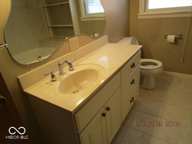 bathroom with baseboards, vanity, toilet, and tile patterned floors