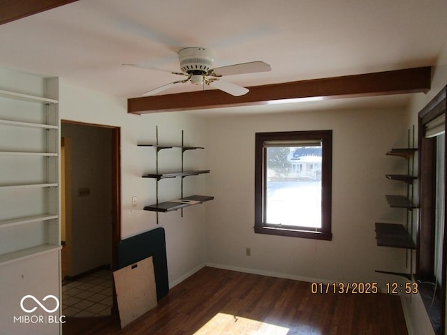 interior space with ceiling fan, baseboards, beam ceiling, and wood finished floors