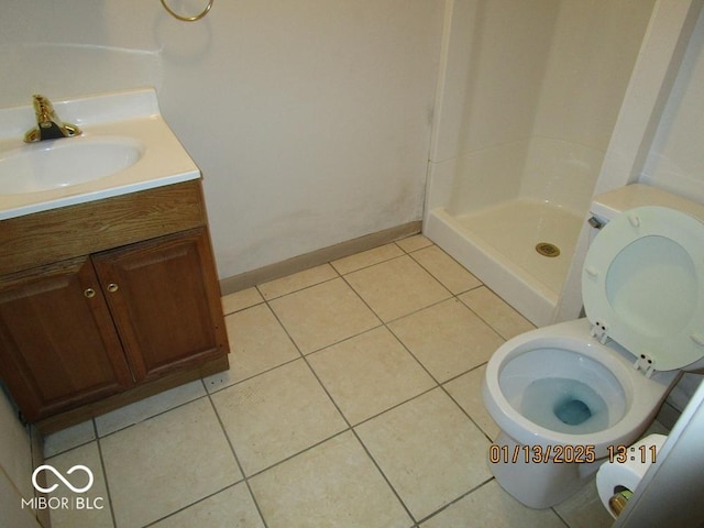 bathroom featuring a stall shower, baseboards, toilet, tile patterned flooring, and vanity