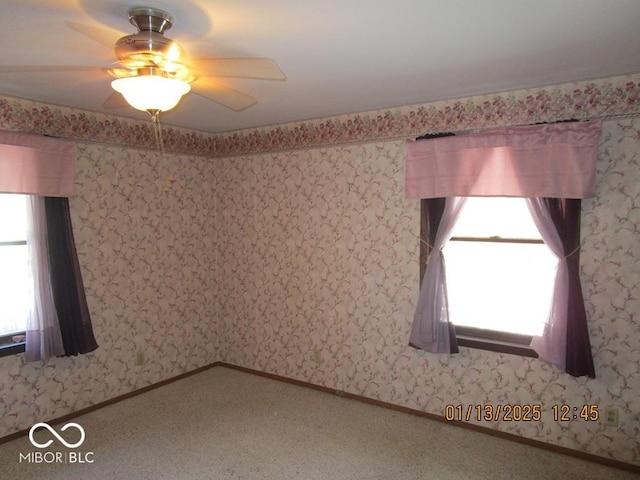 carpeted spare room with baseboards, plenty of natural light, and wallpapered walls