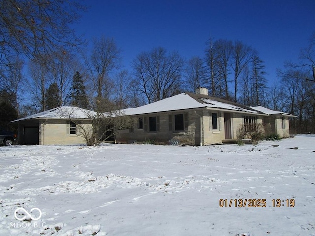 view of front of home featuring stone siding, a chimney, and an attached garage