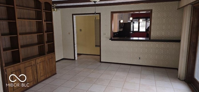 spare room with baseboards and wallpapered walls