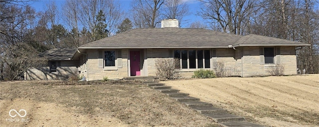 view of front of property with stone siding, a chimney, and roof with shingles