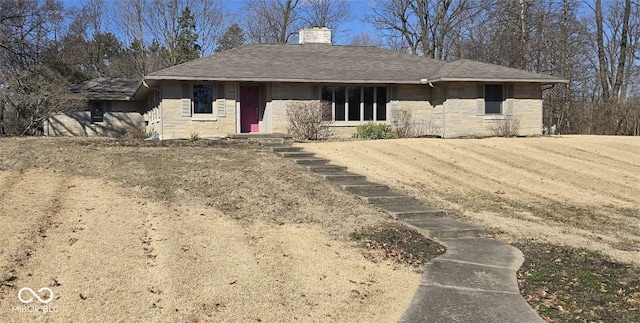 view of front of property with stone siding, a shingled roof, and a chimney