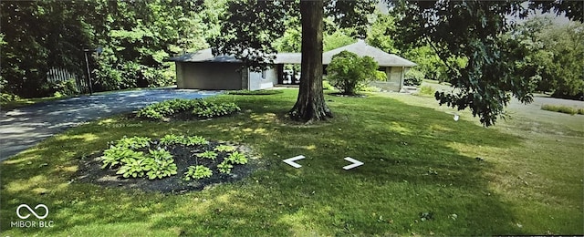 view of front of property featuring a garage, driveway, and a front yard