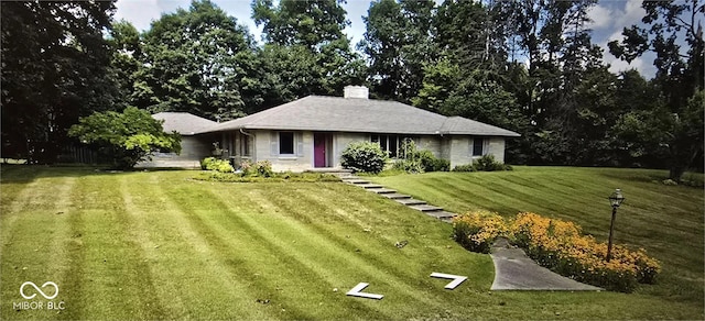 ranch-style house featuring driveway, a chimney, and a front yard