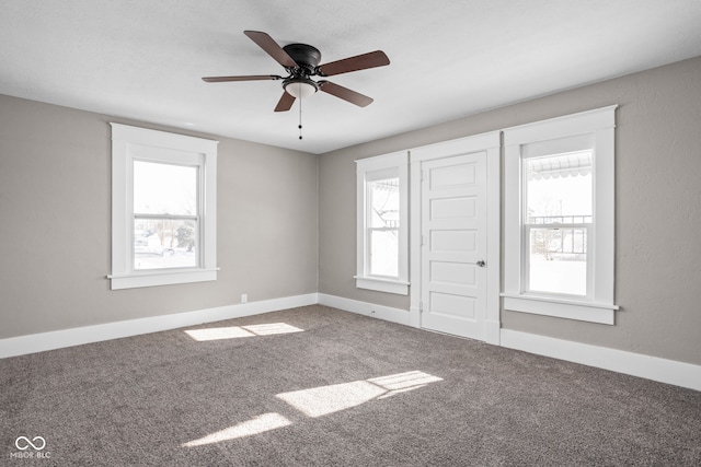 carpeted spare room featuring ceiling fan and a healthy amount of sunlight