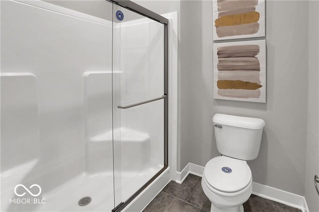 full bath featuring toilet, a stall shower, tile patterned flooring, and baseboards