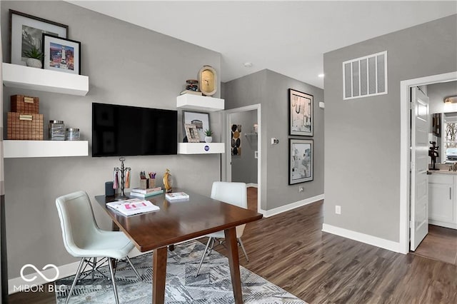 office with dark wood finished floors, visible vents, and baseboards