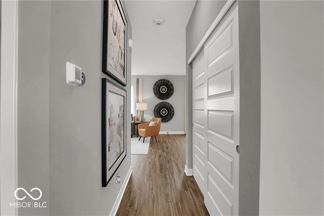 hallway featuring dark wood-style floors and baseboards