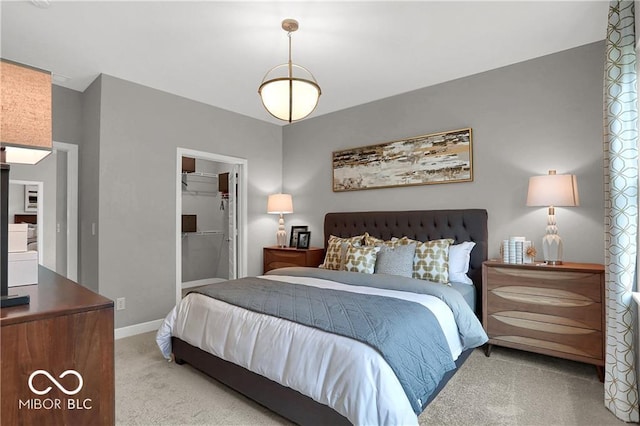 carpeted bedroom with a closet, a spacious closet, and baseboards