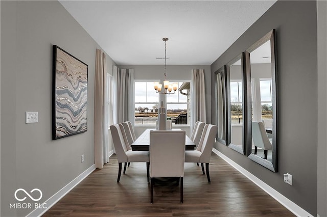 dining room with a chandelier, dark wood-style flooring, and baseboards